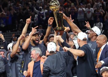 The New York Knicks players and staff celebrate with the Larry O'Brien Championship Trophy after winning Game 5 of the 2026 NBA Finals.
