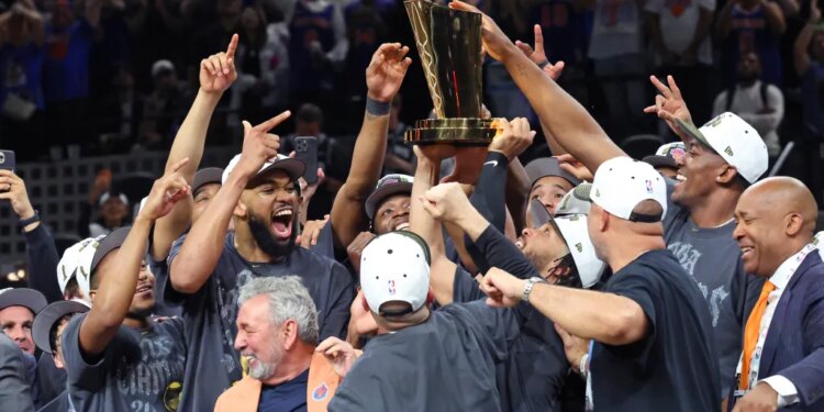 The New York Knicks players and staff celebrate with the Larry O'Brien Championship Trophy after winning Game 5 of the 2026 NBA Finals.