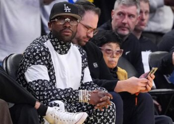 Floyd Mayweather sitting courtside during an NBA basketball game.