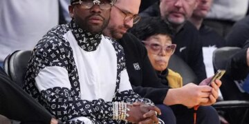 Floyd Mayweather sitting courtside during an NBA basketball game.