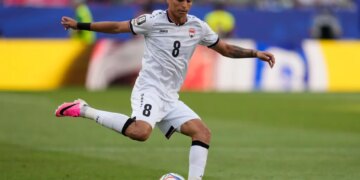 Iraq's Ibrahim Bayesh (8) passes the ball during a soccer match.