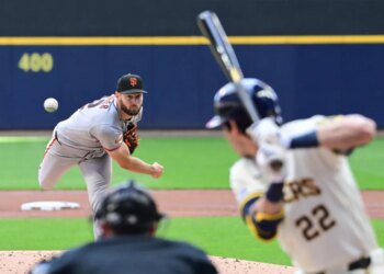 Baseball pitcher Adrian Houser throwing a pitch to a batter.