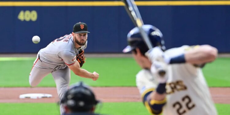 Baseball pitcher Adrian Houser throwing a pitch to a batter.