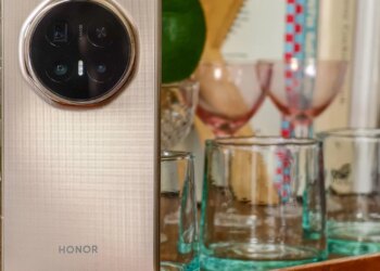 Photo of Honor Magic V6 on a wooden trolley with a pot plant and glassware, closed and showing the rear