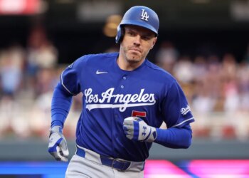A Dodgers baseball player in a blue uniform and helmet running.