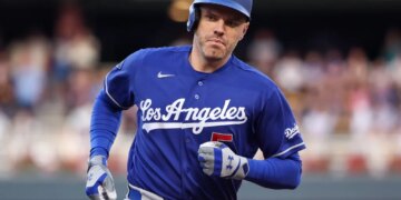 A Dodgers baseball player in a blue uniform and helmet running.