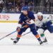 New York Islanders center Marc Gatcomb and Vancouver Canucks left wing Kiefer Sherwood chase the puck.