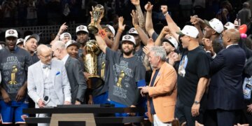 New York Knicks guard Jalen Brunson holds up the MVP trophy after winning the NBA Championship.