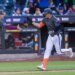 New York Mets first baseman Jared Young is high-fiving a coach after scoring a solo home run.