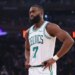 Jaylen Brown of the Boston Celtics wearing a white jersey with green trim and the number 7, hands on hips, looking intently to the left.