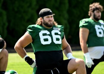 Jets center Joe Tippmann (66) stretches at practice.