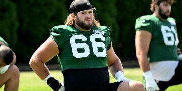 Jets center Joe Tippmann (66) stretches at practice.