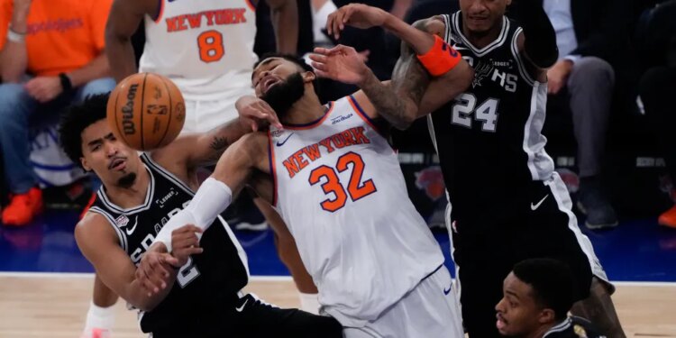 New York Knicks center Karl-Anthony Towns (32), San Antonio Spurs guard Dylan Harper (2) and guard Devin Vassell (24) battle for the ball during the first half of Game 3 of the NBA Finals basketball series, Monday, June 8, 2026, in New York.