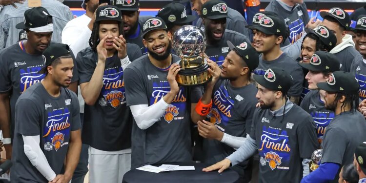 Knicks center Karl-Anthony Towns (32) and the New York Knicks hold up the Eastern Conference Finals trophy at the end the fourth quarter.