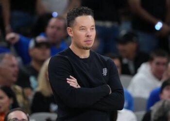 Mitch Johnson, head coach of the San Antonio Spurs, watching an NBA Finals game.