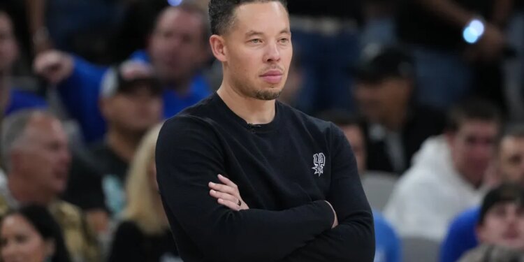 Mitch Johnson, head coach of the San Antonio Spurs, watching an NBA Finals game.