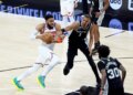 New York Knicks center Karl-Anthony Towns drives down court as San Antonio Spurs forward Victor Wembanyama gives chase during Game 1 of the NBA Finals.