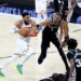 New York Knicks center Karl-Anthony Towns drives down court as San Antonio Spurs forward Victor Wembanyama gives chase during Game 1 of the NBA Finals.