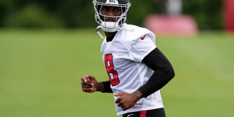 Kyle Pitts in a white jersey with a black helmet and number 8, looking to his right.