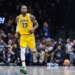 LeBron James wearing a yellow Los Angeles Lakers jersey with "23" on it, running on a basketball court.