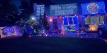 A Long Island house decorated with blue and orange lights and signs for the NBA finals.