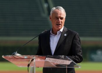 MLB Commissioner Rob Manfred speaks at a podium in Chicago.