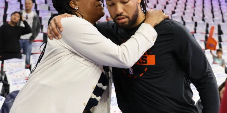 Jalen Brunson hugs his mother, Sandra Brunson, during warm-ups for an NBA Playoffs game.