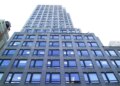 A low-angle view of 667 Madison Avenue & 61st Street, a tall building with many reflective windows.