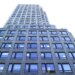 A low-angle view of 667 Madison Avenue & 61st Street, a tall building with many reflective windows.
