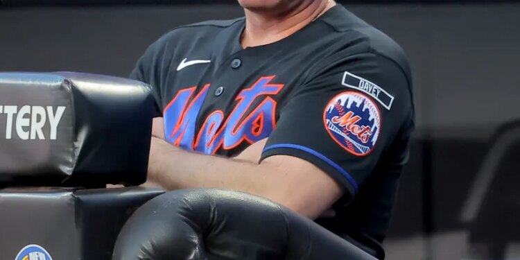 New York Mets manager Carlos Mendoza watching from the dugout.