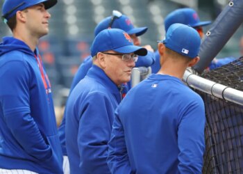 New York Mets owner Steve Cohen speaking with bench coach Kai Correa before a game.