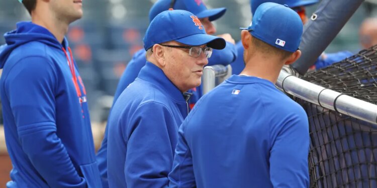 New York Mets owner Steve Cohen speaking with bench coach Kai Correa before a game.