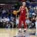 A Louisville player in a red jersey and a SMU player in a white jersey on the basketball court.