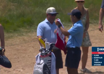 Miles Russell's dad, Joe, given the caddie bib ahead of the 18th hole at the U.S. Open on Sunday.