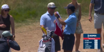 Miles Russell's dad, Joe, given the caddie bib ahead of the 18th hole at the U.S. Open on Sunday.