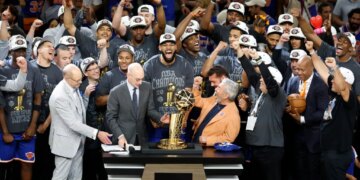 The New York Knicks team and owner James Dolan celebrate with the 2026 NBA Finals trophy.