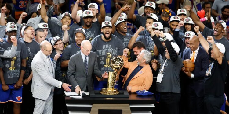 The New York Knicks team and owner James Dolan celebrate with the 2026 NBA Finals trophy.