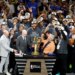 The New York Knicks team and owner James Dolan celebrate with the 2026 NBA Finals trophy.