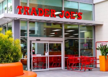 Exterior of a Trader Joe's grocery store with red shopping carts outside the entrance.
