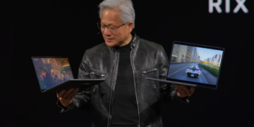 Nvidia’s CEO holds up two RTX Spark laptops at Computex.
