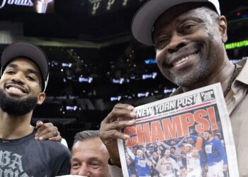 A smiling Patrick Ewing celebrates with Karl-Anthony Towns and a copy of the New York Post front page after the Knicks' 94-90 NBA title-clinching Game 5 win over the Spurs on July 13, 2026 in San Antonio.
