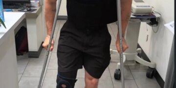 A person with a knee brace and crutches.