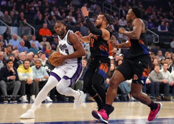 Sacramento Kings player Precious Achiuwa drives to the basket as New York Knicks players Jalen Brunson and OG Anunoby give chase.