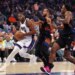Sacramento Kings player Precious Achiuwa drives to the basket as New York Knicks players Jalen Brunson and OG Anunoby give chase.