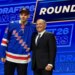 Alberts Smits, left, wearing a blue New York Rangers jersey, stands with NHL Commissioner Gary Bettman, right, at the NHL draft.