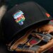A black San Francisco Giants baseball cap with a rainbow "SF" logo rests on a baseball glove.