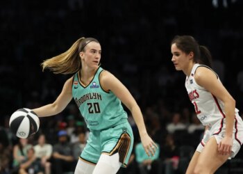 New York Liberty guard Sabrina Ionescu dribbling the ball while defended by Washington Mystics guard Sonia Citron.