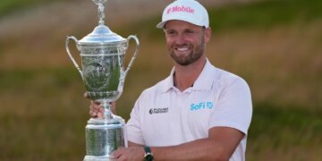 Wyndham Clark holds the trophy after winning the U.S. Open golf tournament at Shinnecock Hills Golf Club in Southampton, N.Y., Sunday, June 21, 2026.