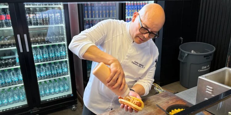 Executive sous chef Camilo Baquero prepares the fried Ripper Hot Dog with pineapple salsa, ketchup mayo, diced pineapple and potato sticks.