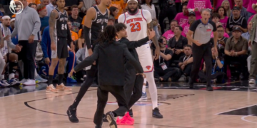 Victor Wembanyama and Mitchell Robinson watch as a fan runs onto the court.